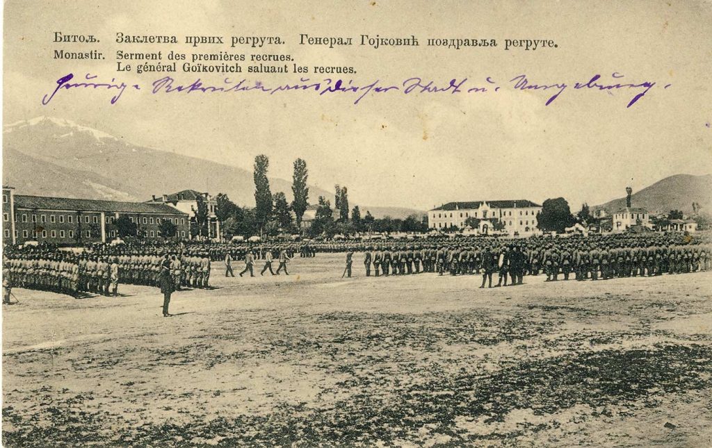 Заклетва на првите ре­грути пред генералот Гојковиќ во Битола во пролетта 1913 година. На левата страна се гледа Црвената касарна и Пе­листер во заднината, а кон средината е Воената академија.